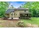 Exterior back of house with covered porch, patio, seating, and a basketball hoop in the backyard at 135 Crimson Rdg, Tyrone, GA 30290
