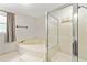 Bathroom featuring a tub, glass door shower, and window at 135 Crimson Rdg, Tyrone, GA 30290