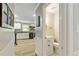 Hallway view of a kitchen and a half bath with a white vanity, toilet and sink at 135 Crimson Rdg, Tyrone, GA 30290