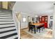 Dining room with a wooden table and chairs, red china cabinet, and stairs to the second floor at 135 Crimson Rdg, Tyrone, GA 30290