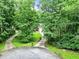 Long driveway leading up to a home surrounded by trees and lush landscaping at 135 Crimson Rdg, Tyrone, GA 30290