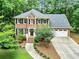 Attractive two-story brick home featuring a two-car garage and lush green surroundings at 135 Crimson Rdg, Tyrone, GA 30290