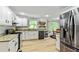 Updated kitchen with white cabinets, granite countertops, stainless steel appliances, and wood-look flooring at 135 Crimson Rdg, Tyrone, GA 30290