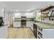 Bright kitchen with white cabinets, granite countertops, stainless steel appliances, and open shelving at 135 Crimson Rdg, Tyrone, GA 30290