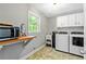Functional laundry room with washer, dryer, utility sink, and ample cabinet space at 135 Crimson Rdg, Tyrone, GA 30290