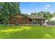 View of the back exterior of the brick home with covered patio and well-maintained lawn at 1738 Sherry Ln, Jonesboro, GA 30236