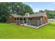 View of the back exterior of the brick home with covered patio and very large yard at 1738 Sherry Ln, Jonesboro, GA 30236