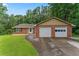 Traditional brick home featuring a two-car garage and a lush green yard in a serene setting at 1738 Sherry Ln, Jonesboro, GA 30236