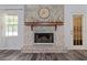 Close-up view of a brick fireplace in a living area with wood-style floors and a window at 1738 Sherry Ln, Jonesboro, GA 30236