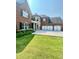 Traditional brick home with three car garage, well-manicured lawn, and mature landscaping at 3499 Lake Mill Rd, Buford, GA 30519