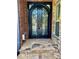 Elegant black arched double doors with decorative ironwork and stone steps, adding a touch of sophistication to the entrance at 3499 Lake Mill Rd, Buford, GA 30519