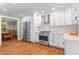 Open kitchen showcases stainless steel appliances, white cabinets and flows seamlessly into dining area at 970 Pine Grove Pointe Dr, Roswell, GA 30075
