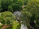Stunning aerial view of a well-maintained home with mature trees, manicured lawn, and a long driveway, exuding curb appeal at 9975 Groomsbridge Rd, Johns Creek, GA 30022