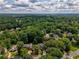 Scenic aerial view of a neighborhood nestled among lush trees and greenery, offering a peaceful and picturesque setting at 9975 Groomsbridge Rd, Johns Creek, GA 30022
