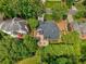 Aerial perspective of a property showcasing the home's layout with deck surrounded by mature trees, ensuring privacy at 9975 Groomsbridge Rd, Johns Creek, GA 30022
