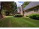 Manicured backyard features mature trees and greenery, with a fence offering added privacy and security at 9975 Groomsbridge Rd, Johns Creek, GA 30022