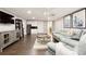 Finished basement living area with a kitchenette, gray leather couch, and wood flooring at 9975 Groomsbridge Rd, Johns Creek, GA 30022