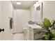Bright bathroom with white vanity, marble countertop, and a shower with curtain at 9975 Groomsbridge Rd, Johns Creek, GA 30022