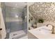 Stylish bathroom with tiled walk-in shower featuring pebble floor, glass door, and attractive floral wallpaper design at 9975 Groomsbridge Rd, Johns Creek, GA 30022