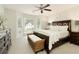 Warm bedroom with large window, plush carpet, and dark wood furniture creates an inviting and relaxing atmosphere at 9975 Groomsbridge Rd, Johns Creek, GA 30022