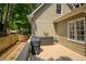 Wooden deck with a grill, gravel, wooden fence and a view of green trees at 9975 Groomsbridge Rd, Johns Creek, GA 30022