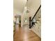 Light-filled foyer showcasing hardwood floors and a staircase with black wrought iron railings at 9975 Groomsbridge Rd, Johns Creek, GA 30022