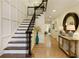 Spacious foyer with hardwood floors, a staircase with wrought iron railings, and a decorative mirror at 9975 Groomsbridge Rd, Johns Creek, GA 30022