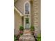 Close up of front entrance with a stone pathway leading to a light green door with a floral wreath at 9975 Groomsbridge Rd, Johns Creek, GA 30022