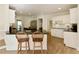 Bright kitchen with a breakfast bar, white cabinets, black granite counters and stainless steel appliances at 9975 Groomsbridge Rd, Johns Creek, GA 30022
