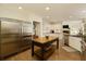 Spacious kitchen boasting stainless steel appliances, a center island, and hardwood floors at 9975 Groomsbridge Rd, Johns Creek, GA 30022