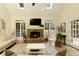 Comfortable living room with a fireplace, large windows, and natural light at 9975 Groomsbridge Rd, Johns Creek, GA 30022