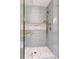Elegant walk-in shower with blue tile, a glass door, and a built-in seat offers a luxurious bathing experience at 9975 Groomsbridge Rd, Johns Creek, GA 30022