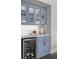 Stylish bar area with blue cabinets, glass displays, and a built-in wine refrigerator at 244 Citrine Way, Acworth, GA 30101