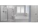 Bright bathroom with a soaking tub, white marble tile, and a glass-enclosed shower at 244 Citrine Way, Acworth, GA 30101
