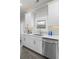 Another view of the white kitchen, showing the stainless steel sink and appliances, with natural light at 244 Citrine Way, Acworth, GA 30101