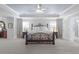 Spacious main bedroom featuring a tray ceiling, a decorative bed frame, and an adjoining bathroom at 244 Citrine Way, Acworth, GA 30101