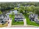 Aerial view of elegant modern homes with manicured lawns, showcasing the neighborhood's appeal and serene lakeside at 7420 Wild Violet Dr, Cumming, GA 30040