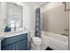 Bathroom with blue vanity, a mirror, a toilet, and a shower/tub with blue patterned shower curtain at 7420 Wild Violet Dr, Cumming, GA 30040