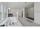 Bright bathroom with a soaking tub, a walk-in shower with glass door and tile, plus sleek fixtures at 7420 Wild Violet Dr, Cumming, GA 30040