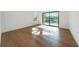 Bedroom with hardwood floors, large window and sliding door access to a deck with views of green trees at 7420 Wild Violet Dr, Cumming, GA 30040