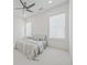 A bedroom featuring a queen-sized bed with a striped duvet cover, two windows with white blinds and a ceiling fan at 7420 Wild Violet Dr, Cumming, GA 30040