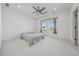 Bedroom with ceiling fan, light carpet, large windows with bright natural light and view of houses at 7420 Wild Violet Dr, Cumming, GA 30040