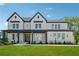 Beautiful two-story home features a well-manicured lawn, inviting front porch, and classic design elements at 7420 Wild Violet Dr, Cumming, GA 30040