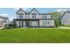 Inviting curb appeal of a two-story home showcasing a green lawn and a charming front porch at 7420 Wild Violet Dr, Cumming, GA 30040