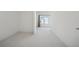 Bright hallway with neutral carpet leading to a bedroom with large windows and natural light at 7420 Wild Violet Dr, Cumming, GA 30040