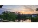 Scenic pond view with colorful sunset sky and lush greenery reflecting in water at 7420 Wild Violet Dr, Cumming, GA 30040