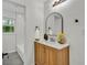 Modern bathroom with a wood vanity, arched mirror, and natural light streaming through the window at 1769 W Austin Rd, Decatur, GA 30032
