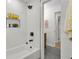 Bright bathroom featuring tiled walls, a shower head, and a built-in niche shelf with decorative flowers at 1769 W Austin Rd, Decatur, GA 30032