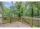 A wooden back porch with railing that overlooks a wooded yard at 2128 Kimberly Rd, Atlanta, GA 30331
