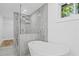 Luxurious bathroom features a glass shower, soaking tub, tile accents and natural light at 2128 Kimberly Rd, Atlanta, GA 30331